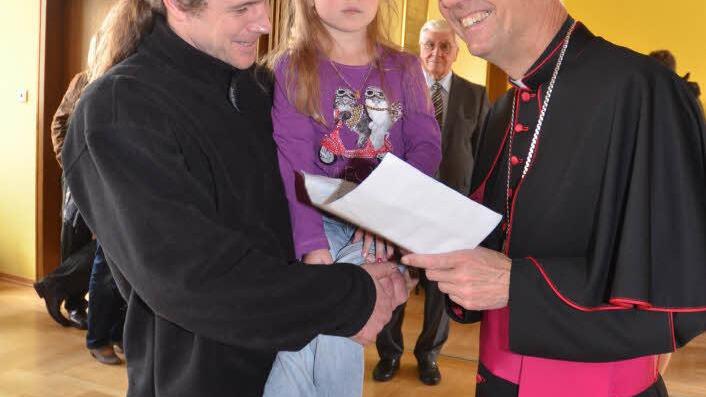 Sichtlich erfreut nahm Erzbischof Ludwig Schick ein Gemälde-Geschenk von der fünfjährigen Hanna mit deren Signatur entgegen.