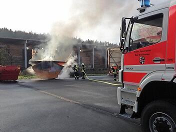 Unter Einsatz von Atemschutz löschten Einsatzkräfte der Feuerwehr den brennende Container neben einer Schreinerei im Gewerbegebiet Buchrasen.  Foto: Feuerwehr Bad Brückenau/Sven Wiesner