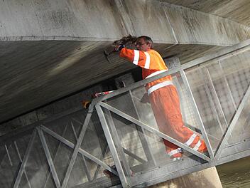 Ingenieur Klaus Schneider klopft den Unterbau der Aischbrücke ab.  Fotos: Sabine Herteux