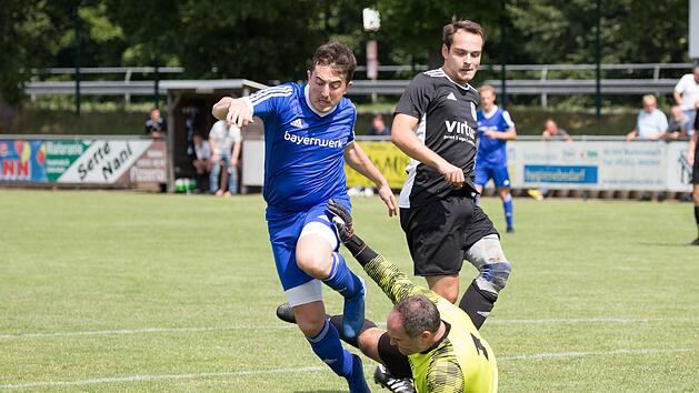 Der Unterrodacher Keeper Sven Hammer kommt aus seinem Kasten und behindert den Wallenfelser Torj&auml;ger Matthias Zeitler (blaues Trikot) erfolgreich.  Fotos: Heinrich Wei&szlig;