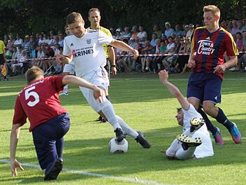 Hart umkämpft war das Hinspiel in Augsfeld vor 1000 Zuschauern Die Sander (weiße Trikots) mit Dinis Ribeiro (am Boden) und Fabian Benkert (Zweiter von links) versuchen, die Augsfelder Abwehr (mit der Nummer 5 Patrick Lugert, rechts Dominik Rippstein) zu knacken.
