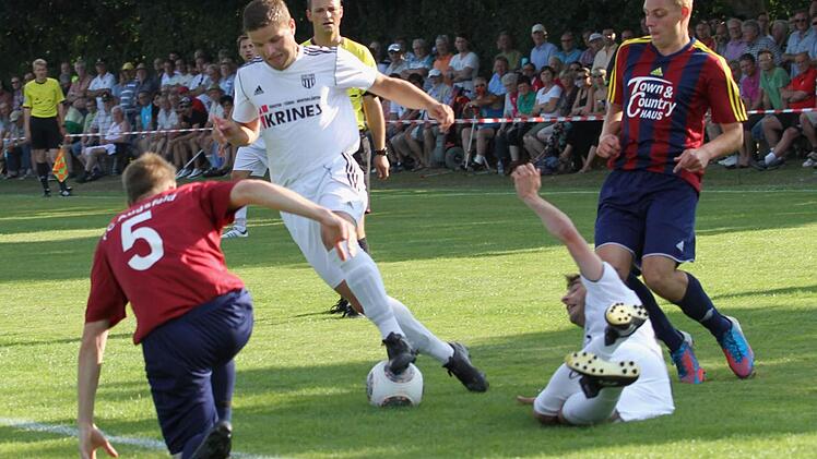 Hart umkämpft war das Hinspiel in Augsfeld vor 1000 Zuschauern Die Sander (weiße Trikots) mit Dinis Ribeiro (am Boden) und Fabian Benkert (Zweiter von links) versuchen, die Augsfelder Abwehr (mit der Nummer 5 Patrick Lugert, rechts Dominik Rippstein) zu knacken.