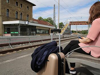 Eine junge Frau wartet mit gepacktem Koffer am Bahnhof in Haßfurt. Wohin wohl die Reise geht? Mit der Bahn zum nächsten Flughafen und dann ins Ausland - oder per Zug zum inländischen Reiseziel ?  Foto: Jutta Rudel