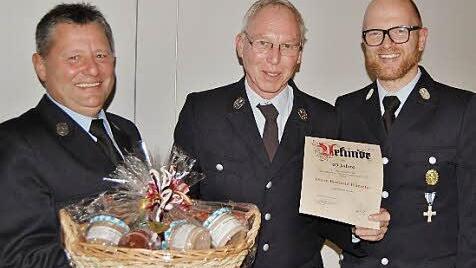 Auszeichnung: Vorsitzender Harald Neugebauer (links) und Kommandant Jörg Rumberg (rechts) danken Berthold Hümpfer für seine 40-jährige Mitgliedschaft. Foto: Sigismund von Dobschütz