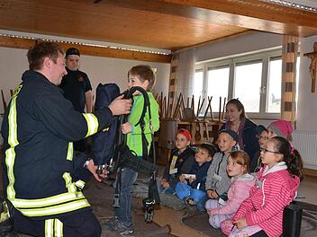Joel kann sich selbst davon überzeugen, wie schwer eine Pressluftatmer ist, den der Feuerwehrmann beim Einsatz tragen muss.  Foto: Björn Hein