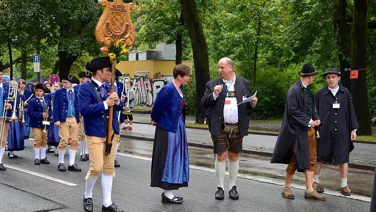 Letzte Absprachen mit dem Fernsehredakteur des Bayerischen Rundfunks. Hier stehen die Bläser in der Widenmayerstraße. Links im Bild ist Schildträger Jan Katzenberger zu sehen, rechts Felix, der Zug-Begleiter.  Foto: Kathrin Kupka-Hahn