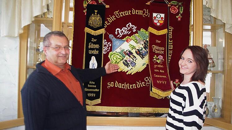 "Der Heimat die Liebe, die Treue dem Brauch, so dachten die Alten, so denken wir auch". In goldener Schrift prangt dieser Spruch auf der in Weinrot gehaltenen "Alt Kronach"-Vereinsfahne aus dem Jahr 1997. Interessiert hört die frischgebackene Schriftführerin den Erläuterungen des Ersten Vorsitzenden Thomas Heider zu.  Foto: Heike Schülein