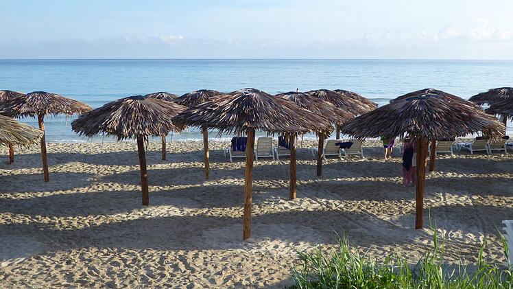Sonnenschirme am Strand und blaues Meer vorher...