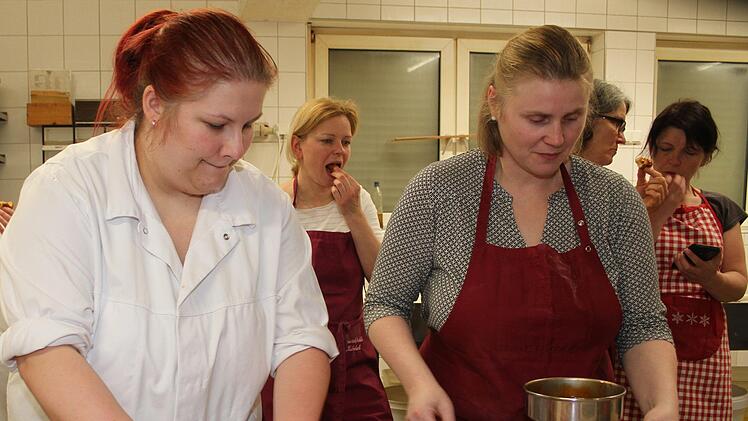 Christina Kortschack und Dagmar Stübinger füllen die Krapfen mit vereinten Kräften: Mit der Profispritze geht dies ganz leicht. Foto: Sonny Adam