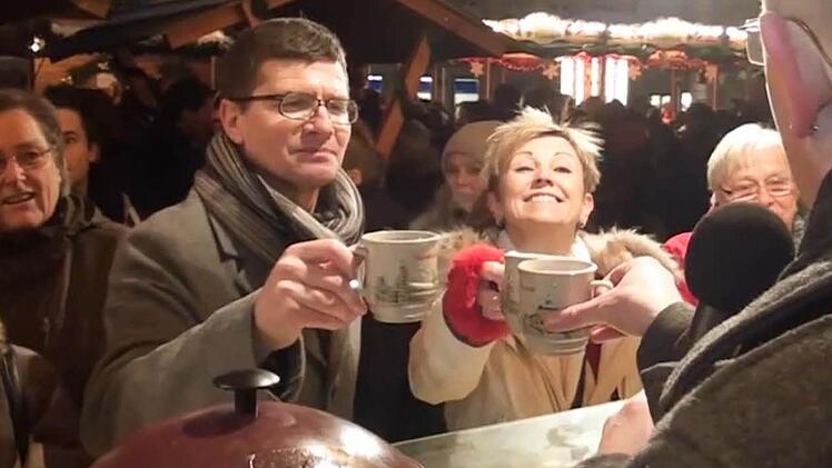 Ein Tässchen Glühwein zum Aufwärmen: Mäc Härder, Heidi Schütz und Jo Farmer bei ihrem Rundgang auf dem Bamberger Weihnachtsmarkt.