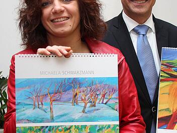 Michaela Schwarzmann und Gregor Scheller, Leiter der Vollksbank Forchheim, präsentieren den Kunstkalender 2013.   "Ein Kalender, der mehr ist, als nur Technik" fand Vorstandsvorsitzender Scheller. Foto: Hofbauer