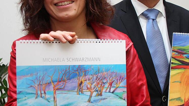 Michaela Schwarzmann und Gregor Scheller, Leiter der Vollksbank Forchheim, präsentieren den Kunstkalender 2013.   "Ein Kalender, der mehr ist, als nur Technik" fand Vorstandsvorsitzender Scheller. Foto: Hofbauer