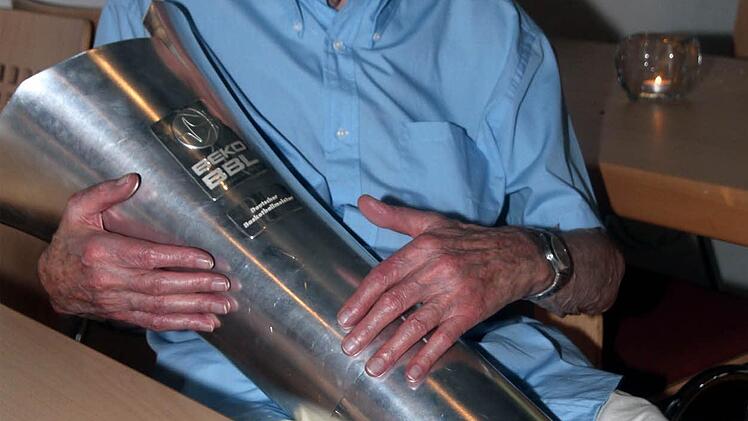 Basketball-"Vater" Bert Peßler: Mit 89 Jahren hält er die Meister-Trophäe eng umschlungen und überglücklich.