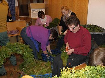 Die einen schneiden, die anderen binden. Foto: Carmen Schwind