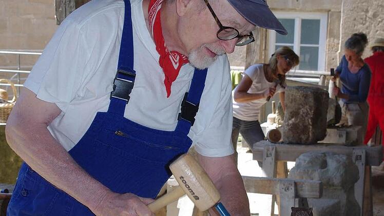 Rainer Vormbrock möchte aus Sandstein eine Eule schaffen. Den Prototyp hat er auf seinen Stein gestellt. Fotos: Heike Schülein