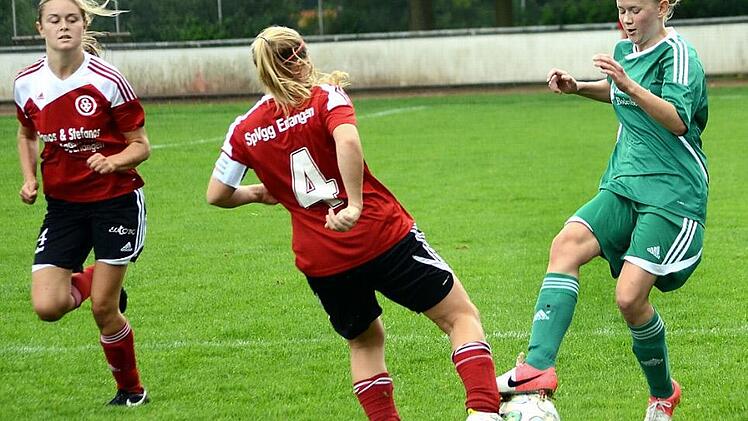 SpVgg Erlangen II - TSV Lonnerstadt. Gästestürmerin Christina Spörl (rechts) beißt sich an der Erlanger Spielführerin Susanne Klotz die Zähne aus. Michaela Pflaum (links) beobachtet die Szene. Foto: herzopress