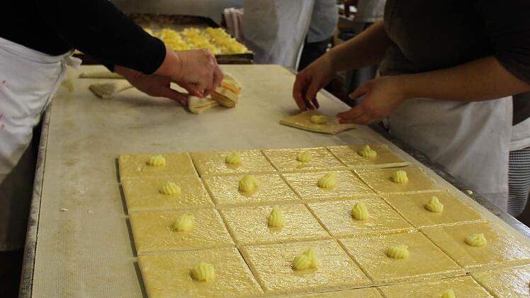 Viele Hände fertigen routiniert die Gebäckstücke an. Foto: Julia Raab