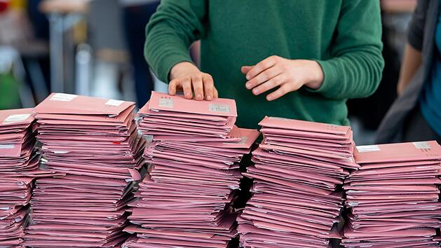 Wahlhelfer bereiten in einer Messehalle die Auszählung der Briefwahl vor.