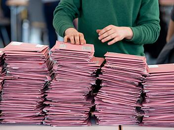 Wahlhelfer bereiten in einer Messehalle die Auszählung der Briefwahl vor.