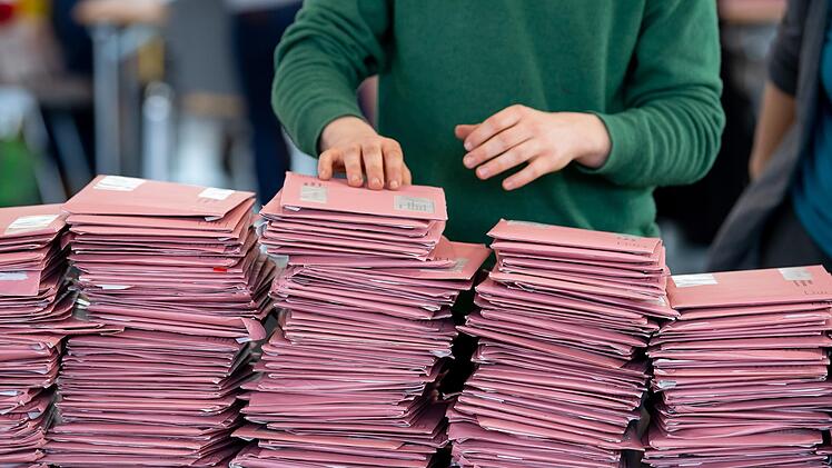 Wahlhelfer bereiten in einer Messehalle die Auszählung der Briefwahl vor.