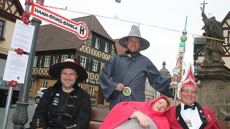 Gag zum 11.11. auf dem Staffelsteiner Marktplatz: Der Staffelsteiner Karnevals-Klub (SKK) eröffnet sein "Haam-Bring-Bänkla". Unter der Aufsicht von Erstem Präsidenten Matthias Graß haben hier (vorn v. l.) Jo Riemer, Margit Schnapp und Michael Hess Platz genommen.Matthias Einwag