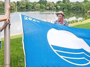 Martin L&uuml;ders (Freizeit-GmbH), Anne Schmitt (Flussparadies Franken) und Anne-Maria Schneider (Kur- und Tourismus-Service) beim Hissen der Blauen Flagge am Ostsee in Bad Staffelstein. Foto: Flussparadies Franken