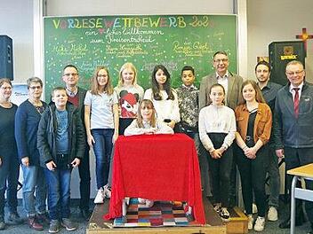 Die Siegerin Anna Müller (Mitte) mit den weiteren Teilnehmern, der Jury sowie Organisator Thomas Hauptmann (vierter von links), Schulleiter Uwe Schönfeld (vierter von rechts) und Moderatorin Monika Kotschenreuther (dritte von rechts).  Foto: Heike Schülein