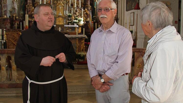 Franziskanerpater Adrian Manderla hat schon viele Pilger getroffen. Reinfried Lengenfelder besucht mit seiner Frau Renate die Basilika immer wieder gerne und erzählt von früheren Pilgerreisen zu Fuß. Doch mit über achtzig Jahren fahren die Lengenfelders jetzt lieber mit dem Auto in die Basilika. Foto: Sonja Adam