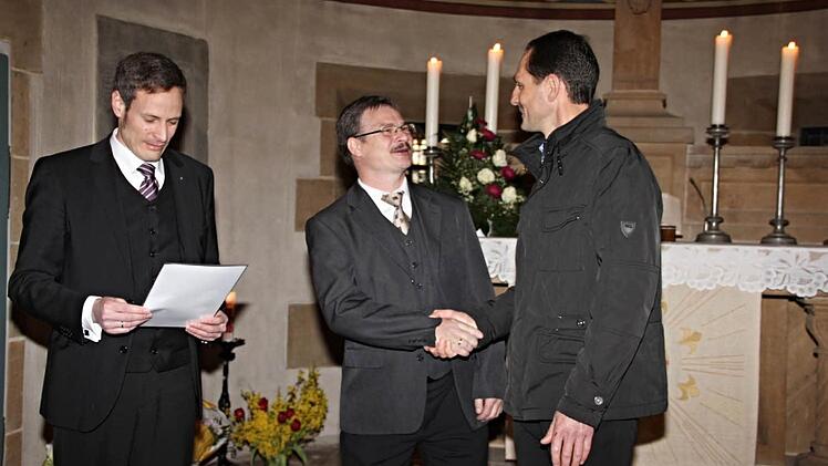 Posaunenchorobmann Pfarrer Peter Bauer (links) und Bezirksposaunenchorleiter Jürgen Koch (rechts), ehrten Andreas Binger für 25jährige Chorleitertätigkeit. Foto: Helmut Will