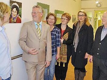 Bei der Vernissage (von links): Pflegedienstleiterin Karin Büttner, Helmut Weiß, Claudia Welsch, Katja Suffa-Weißkopf, Dagmar Alfsmann (Leiterin der Altenpflegeschule) sowie Heinrich Weiß bei der Vernissage. Das Bild zwischen Karin Büttner und Helmut Weiß zeigt die verstorbene Ilse Weiß, welche die Bilder gemalt hat. Foto: Heike Schülein