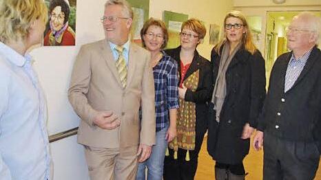 Bei der Vernissage (von links): Pflegedienstleiterin Karin Büttner, Helmut Weiß, Claudia Welsch, Katja Suffa-Weißkopf, Dagmar Alfsmann (Leiterin der Altenpflegeschule) sowie Heinrich Weiß bei der Vernissage. Das Bild zwischen Karin Büttner und Helmut Weiß zeigt die verstorbene Ilse Weiß, welche die Bilder gemalt hat. Foto: Heike Schülein