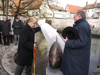 Oberbürgermeister Franz Stumpf und Dieter George (r.), der Vorsitzende des Heimatvereins, enthüllen den bronzenen Cypriniden. Foto: Pauline Lindner