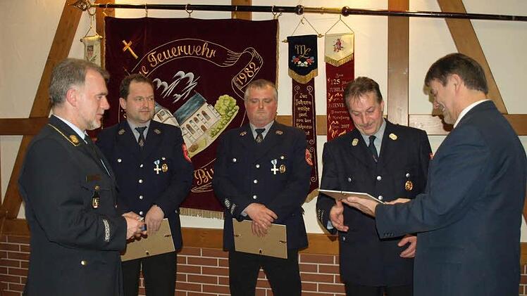 Stellvertretender Landrat Gerhard Wunder (re) zeichnet zusammen mit Kreisbrandrat Joachim Ranzenberger (li) die Kameraden (von links) Stefan Trebes, Fred Gareis und Thomas Kräußling mit dem staatlichen Ehrenkreuz in Silber für 25 Jahre aktiven Dienst aus. Foto: Susanne Deuerling