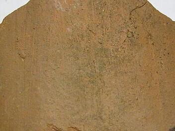 Das Bruchstück eines uralten Ziegels. Die ungleichmäßigen Streifen zeugen von der Produktion durch Menschenhand, die den Ton in seiner Form einst abstrich. Reste von Hohlziegel, heute meist "Mönch und Nonne" genannt, findet man heute am häufigsten.