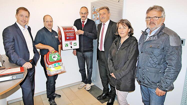 Bei der Präsentation des Defibrillators in der Raiffeisenbank-Filiale in Rannungen: Bankvorstand Michael Hein, Jürgen Müller vom BRK Maßbach und Zentrum Telemedizin, Bürgermeister Fridolin Zehner, Bankvorstand Horst Seufert und die Gemeinderäte Sybille Büttner und Harald Klopf.  Foto: Dieter Britz