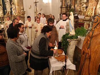 Gottesdienstbesucher zünden ihre Kerzen bei der Madonna zur Prozession an. Foto: Franz Galster