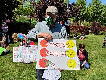 Peter Witton, Veranstalter der Gegendemonstration, erklärt das Infektionsrisiko mit und ohne Maske. Foto: Maria Löffler
