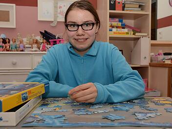Für kleines Geld beim Flohmarkt erstanden: Lisa-Marie liebt Puzzles und setzt sie mit viel Geduld zusammen. Foto: Dagmar Besand