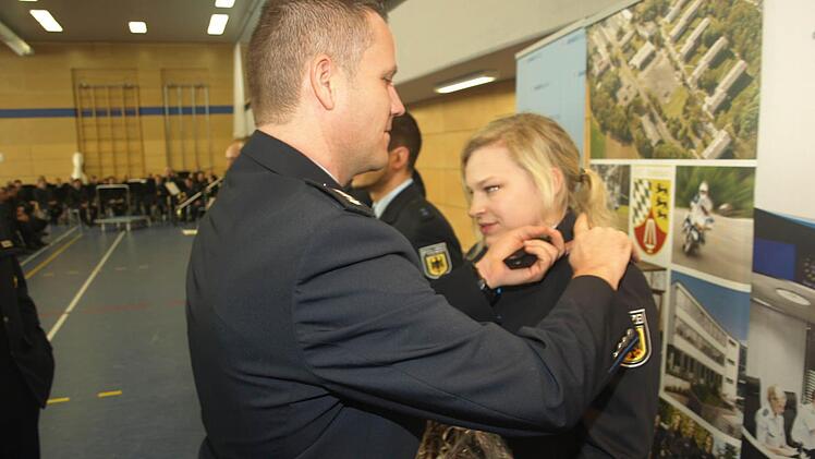 Ausbilder Michael Beyfuß setzt bei Magdalena Woloszyk aus Kaufbeuren das Schulterstück als Beförderung zur Polizeimeisterin ein. Foto: Stefan Geiger
