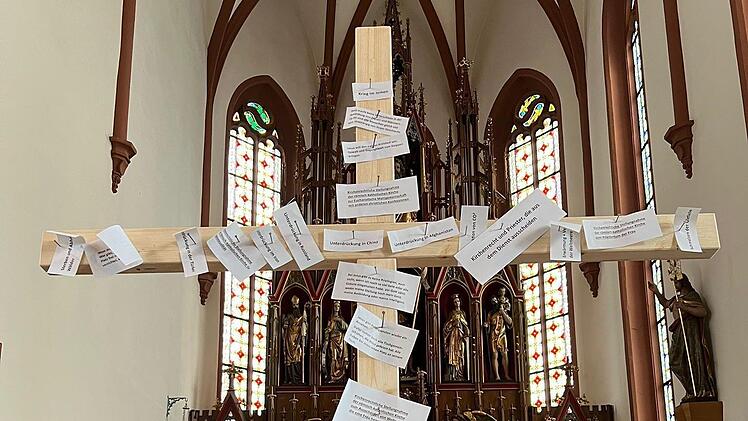 Kirchenrechtliche Aussagen und Evangeliumstexte wurden beim Karfreitagsgottesdienst in Euerdorf an ein Holzkreuz geschlagen.