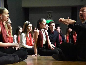 Hubertus Baumann ließ sich mit dem Schulchor auf dem Boden der Bühne nieder und sorgte damit für eine Zusatzportion Gefühl. Foto: Uschi Prawitz