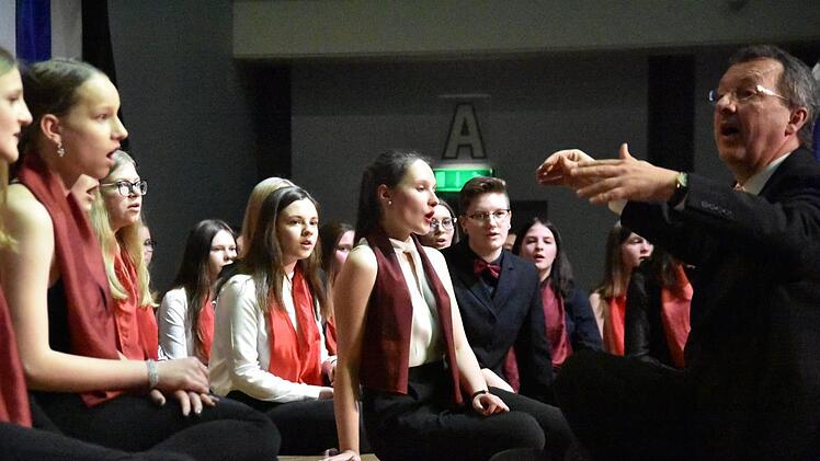 Hubertus Baumann ließ sich mit dem Schulchor auf dem Boden der Bühne nieder und sorgte damit für eine Zusatzportion Gefühl. Foto: Uschi Prawitz