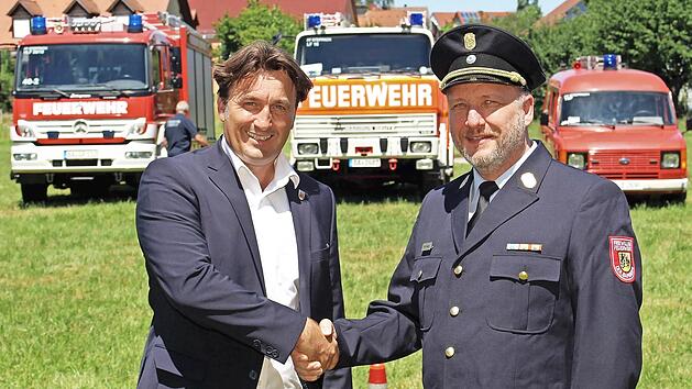 J&ouml;rg Raber (rechts) nimmt beim &bdquo;Blaulichtfest&ldquo; die Gl&uuml;ckw&uuml;nsche von B&uuml;rgermeister Gerd Dallner entgegen.