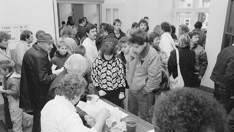 Am 10. November 1989 im ersten Stock des Bamberger Rathauses: Menschen aus der DDR werden in der Warteschlange zum Empfang des Begrüßungsgeldes mit Erfrischungsgetränken versorgt. Foto: Rudolf Mader/ Stadtarchiv