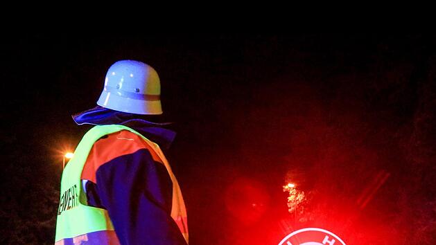Ein Feuerwehrmann sichert den Einsatzort am Sonntag in Stegaurach ab.