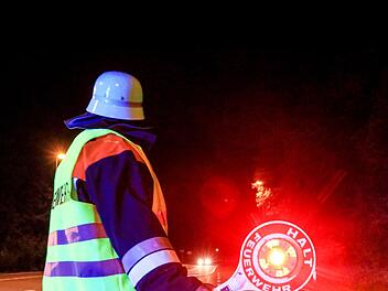Ein Feuerwehrmann sichert den Einsatzort am Sonntag in Stegaurach ab.