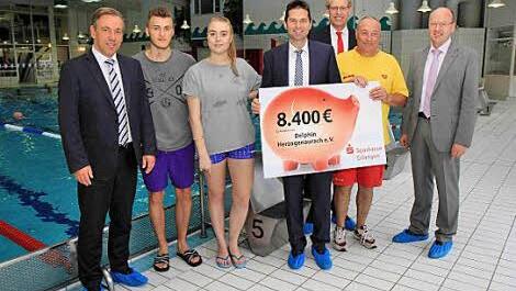 Roland Stopfer h&auml;lt den Spendenscheck in H&auml;nden. Mit im Bild von links Landrat Alexander Tritthart, Sven Bartl, Sandra Gehr, B&uuml;rgermeister German Hacker und Klaus Hentschke, Ausbilder bei der DLRG. Foto: Sae