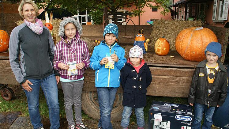 Katrin Ullrich vom Caritas-Kindergartenverein St. Laurentius in Oberschleichach (links) konnte beim Herbstmarkt am Montag zahlreiche Preise vergeben. Den Hauptpreis der Tombola nahm stellvertretend für seine Mama Basti Kraus (rechts) entgegen. Beim Kürbiswettbewerb holten sich die ersten Plätze Emely Kraus, Jannik Krug und seine kleine Schwester Luisa. Fotos: Sabine Weinbeer