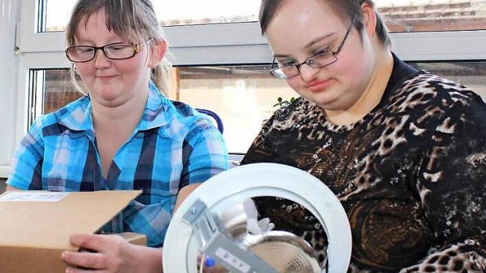 Denise Krause (links) und Carina Pflaum bei ihrer Arbeit, dem Zusammenschrauben und Verpacken von "Downlights". Beiden macht die Arbeit "sehr viel Spaß" und sie möchten "unbedingt weiter hier bleiben".