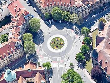 Wie kunstvoll ein Kreisverkehr wirken kann, zeigt dieses Bild vom Bamberger Wilhelmsplatz. Obwohl dieser Kreisel nicht mit Kunst, sondern nur mit Blumen geschmückt wurde. Foto: Ronald Rinklef